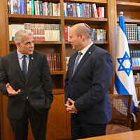 Incoming Prime Minister Yair Lapid (left) is briefed by his predecessor Naftali Bennett at the Prime Minister's Office, June 30, 2022 (Kobi Gideon / GPO)