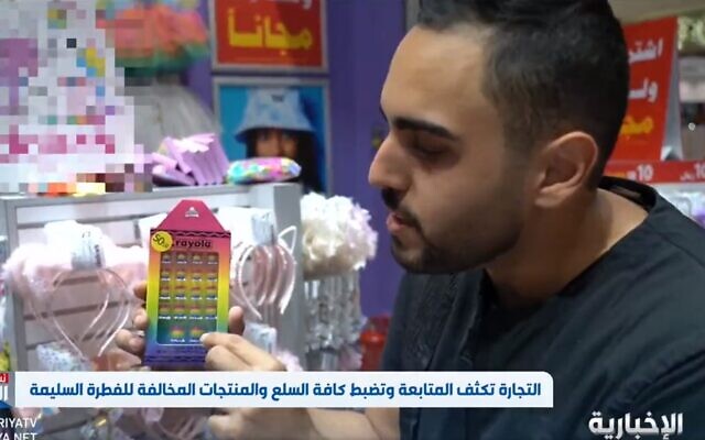 A Saudi reporter points to a rainbow-colored toy seized as part of a crackdown on homosexuality reported by the state-run Al-Ekhbariya news channel on June 14, 2022. (Screenshot: Twitter)