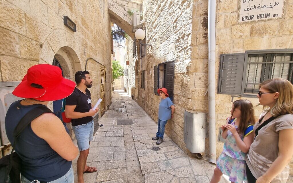Tour guide Idan Pinhas shows participants the site of the first Bikur Holim hospital in Jerusalem's Old City, June 2022. (Shmuel Bar-Am)