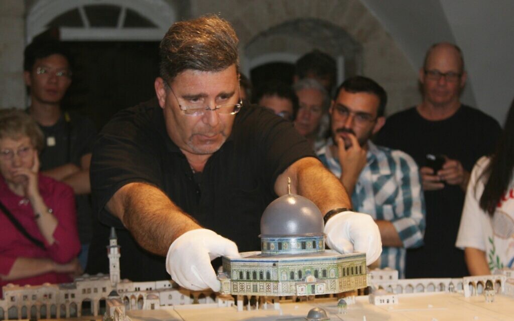 Dr. Eyal Meron liftd the roof off a site in Conrad Schick's model of Jerusalem's Old City, June 2022. (Shmuel Bar-Am)