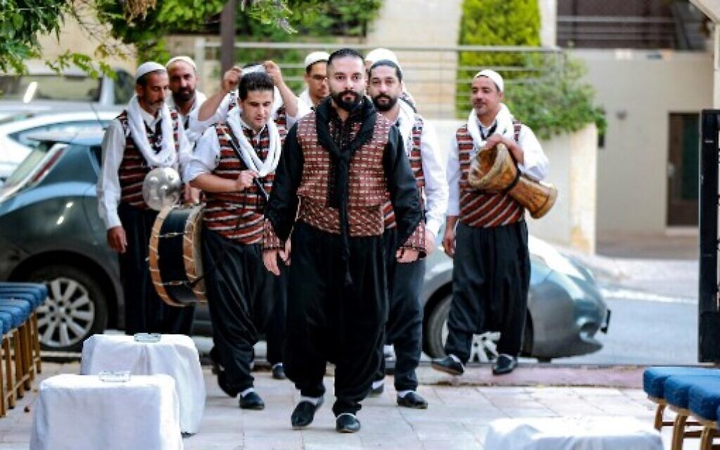 Syrian "Arada" folklore dancers of the "Bab al-Hara" troupe arrive at a venue to perform for a celebration for the graduation of two of the sons of one of their members, Fahed Shehadeh, from universities, in Jordan's capital Amman on June 24, 2022. (Khalil MAZRAAWI / AFP)