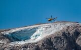 A rescue helicopter flies on July 4, 2022 over the glacier that collapsed the day before on the mountain of Marmolada, the highest in the Dolomites (Pierre TEYSSOT / AFP)
