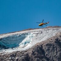 A rescue helicopter flies on July 4, 2022 over the glacier that collapsed the day before on the mountain of Marmolada, the highest in the Dolomites (Pierre TEYSSOT / AFP)