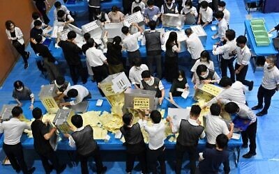 Just two days after the assassination of former prime minister Shinzo Abe, officials of the election administration committee open ballot boxes to count the votes for Japan's upper house election in Tokyo, July 10, 2022. (Kazuhiro Nogi/AFP)