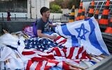 A worker prepares Israeli and US flags on July 12, 2022, in Jerusalem, ahead of US President Joe Biden's visit to Israel. (PAHMAD GHARABLI / AFP)