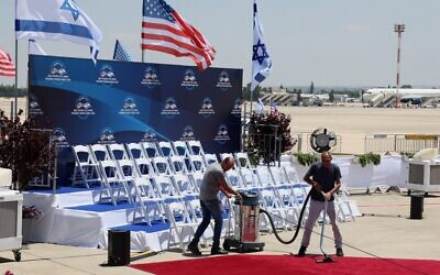 Officials clean the red carpet at Israel's Ben Gurion Airport in Lod near Tel Aviv, on July 13, 2022, ahead of US President Joe Biden's arrival for an official visit. (JACK GUEZ / AFP)