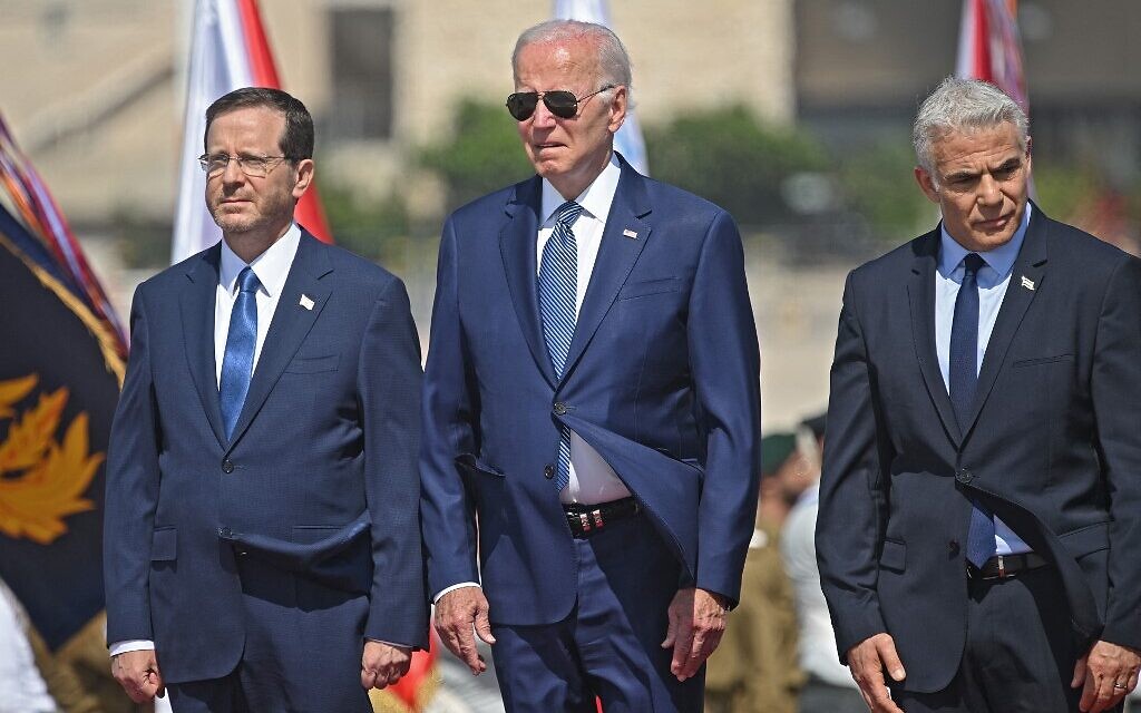 (L to R) President Isaac Herzog, his US counterpart Joe Biden and Prime Minister Yair Lapid listen to th  national anthems at Ben Gurion Airport on July 13, 2022 (MANDEL NGAN / AFP)