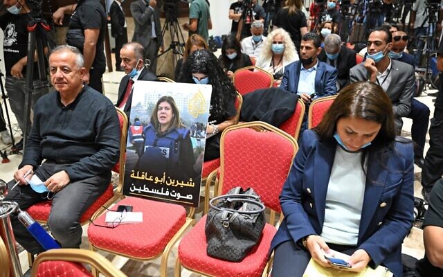 A photo of slain US-Palestinian Al Jazeera correspondent Shireen Abu Akleh, with a caption in Arabic reading "Shireen Abu Akleh, the voice of Palestine," is seen ahead of a joint press conference between the US and Palestinian Authority presidents in Bethlehem on July 15, 2022. (MANDEL NGAN / AFP)