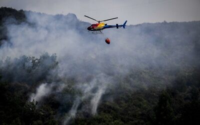 A firefighting helicopter flies over a wildfire near Bustelo village in Amarante, north of Portugal, on July 16, 2022. (PATRICIA DE MELO MOREIRA / AFP)