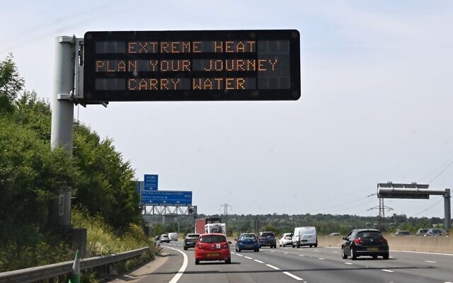 A road sign reads 'Extreme Heat, Plan your journey, Carry water' warning motorists about the heatwave forecast for July 18 and 19, on the M11 motorway north of London on July 17, 2022 (Damien MEYER / AFP)