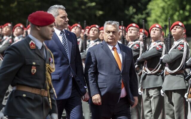Hungarian Prime Minister Victor Orban (R) and Austrian Chancellor Karl Nehammer review an honor guard in front of the Federal Chancellery during Orban's official visit to Austria in Vienna, July 28, 2022. (Alex Halada/AFP)
