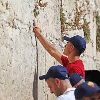 AS Roma's Argentinian striker Paulo Dybala places a note as he prays by the Western Wall in Jerusalem's Old City on July 29, 2022, during a visit alongside his teammates on the eve of their friendly football match with Tottenham Hotspur in the Israeli city of Haifa. (Ahmad Gharabli/AFP)