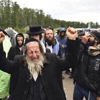 A Hasidic Jewish pilgrim reacts as he joins others, in front of Ukrainian border guards at the checkpoint Novaya Guta near Novaya Guta, Belarus, Friday, Sept. 18, 2020. (AP)