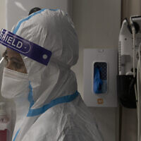 Illustrative image: A medical professional in protective equipment takes a short break, in the coronavirus ward of the Shaare Zedek Medical Center, in Jerusalem, Tuesday, Aug. 31, 2021. (AP Photo/Maya Alleruzzo)