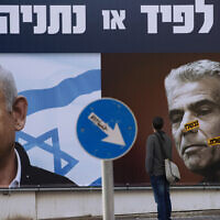 Illustrative image: People stand in front of an election campaign billboard for the Likud party showing a portrait of its leader former prime minister Benjamin Netanyahu, left, and current Prime Minister Yair Lapid, in Ramat Gan, Israel, March 14, 2021. AP Photo/Oded Balilty, File)