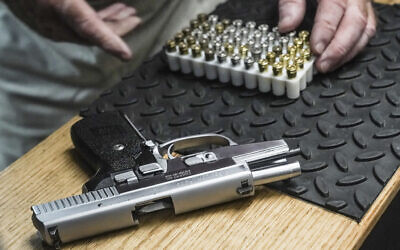 Illustrative: A man prepares to load bullets in his 9mm semi-automatic handgun for a shooting demonstration at his gun range, June 23, 2022, in New York. (AP Photo/Bebeto Matthews)