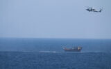 A US Navy Seahawk helicopter flies over a stateless dhow later found to be carrying a hidden arms shipment in the Arabian Sea, May 6, 2021. (US Navy via AP)