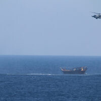 A US Navy Seahawk helicopter flies over a stateless dhow later found to be carrying a hidden arms shipment in the Arabian Sea, May 6, 2021. (US Navy via AP)