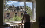 Victor Rosenberg, 81, looks out of a broken window in his home destroyed by the Russian rocket attack in the city center of Bakhmut, Donetsk region,  Friday, July 1, 2022. (AP Photo/Efrem Lukatsky)