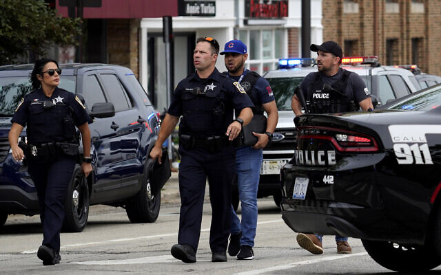 Police search the downtown area in Highland Park after a shooting at a Fourth of July parade, July 4, 2022. (AP Photo/Nam Y. Huh)