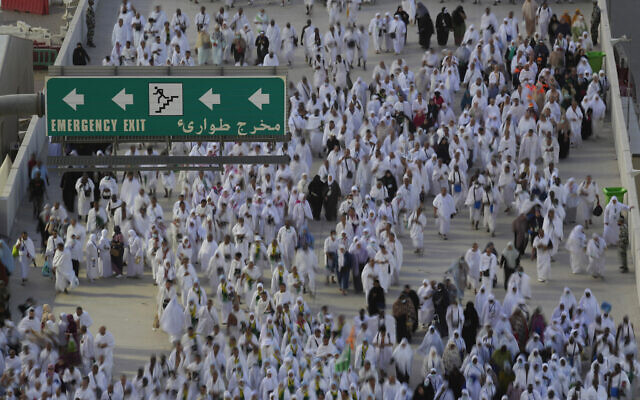 In this photo take by slow shutter, Muslim pilgrims walk to cast stones at a pillar in the symbolic stoning of the devil, during the last rite of the annual hajj, and the first day of Eid al-Adha, in Mina near the city of Mecca, Saudi Arabia, July 9, 2022. (AP Photo/Amr Nabil)
