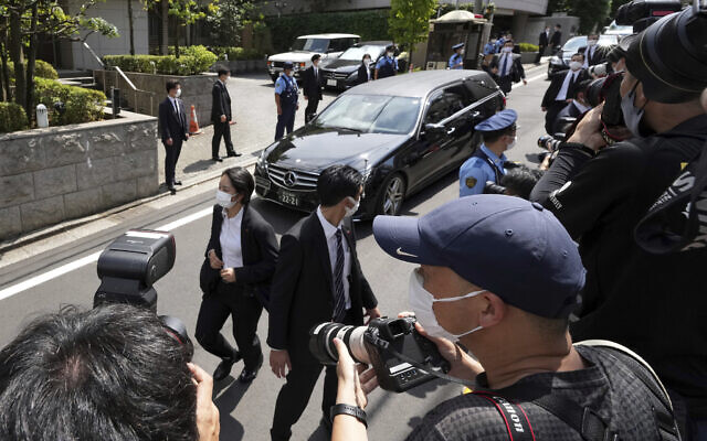 A car which is believed to carry the body of former Prime Minister Shinzo Abe, arrives at his home, July 9, 2022, in Tokyo. (AP Photo/Eugene Hoshiko)