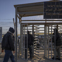Palestinian workers enter Israel after crossing from Gaza, on the Israeli side of Erez crossing between Israel and the Gaza Strip, March 27, 2022. (AP Photo/Oded Balilty, File)