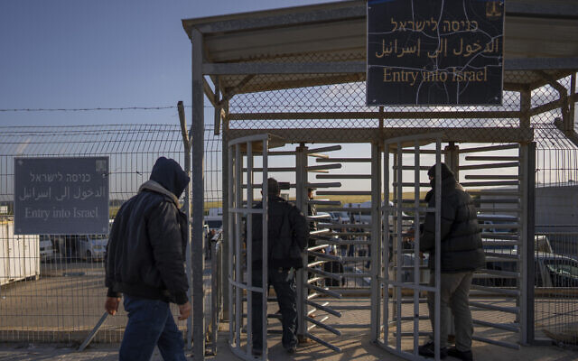 Palestinian workers enter Israel after crossing from Gaza on the Israeli side of Erez crossing between Israel and the Gaza Strip, March 27, 2022. (AP Photo/Oded Balilty, File)