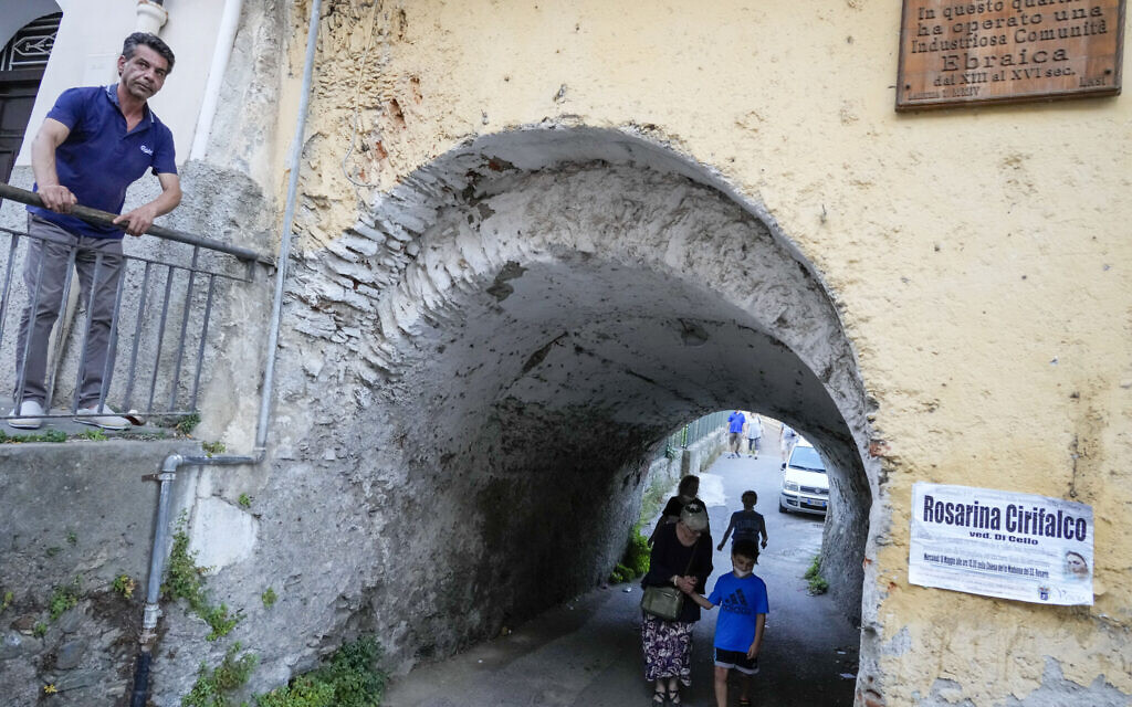 Rabbi Barbara Aiello, bottom center, holds hand with Noah Blum, 10, as she guides him with his family for a tour of the Jewish quarter of Lamezia Terme, southern Italy, July 7, 2022  (AP Photo/Andrew Medichini)