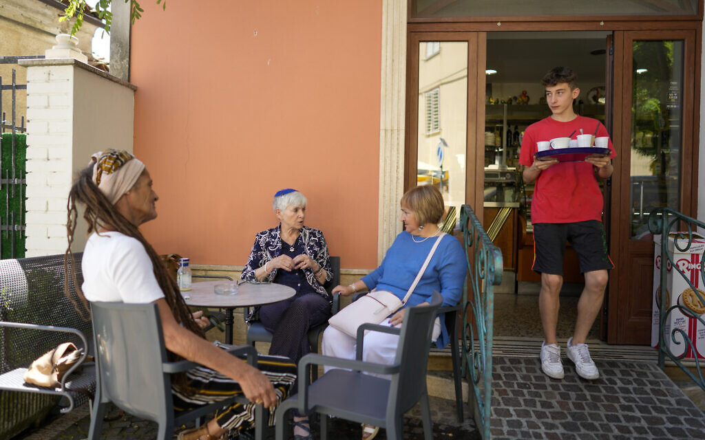 Rabbi Barbara Aiello, second from left, talks with Lidia as they sit at a caffe' in Serrastretta, southern Italy, July 8, 2022 (AP Photo/Andrew Medichini)