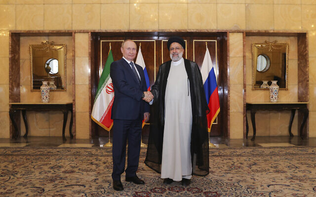 Russian President Vladimir Putin, left, and his Iranian counterpart Ebrahim Raisi shake hands for media at the start of their meeting in Tehran, Iran, Tuesday, July 19, 2022. (Iranian Presidency Office via AP)