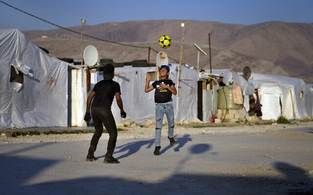 Syrian children play soccer near their tented homes at a refugee camp in the town of Bar Elias, in the Bekaa Valley, Lebanon, July 7, 2022. (AP Photo/Bilal Hussein)