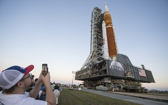 People take photos as NASA's Space Launch System (SLS) rocket with the Orion spacecraft aboard is rolled out for the first time, at the Kennedy Space Center in Cape Canaveral, Florida, March 17, 2022. (Aubrey Gemignani/NASA via AP)