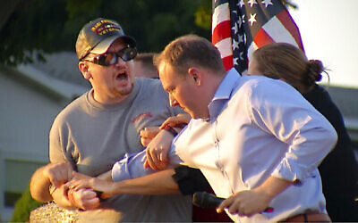 In this image taken from video provided by WHEC-TV, David Jakubonis, left, is subdued as he brandishes a sharp object during an attack US Rep. Lee Zeldin, right, as the Republican candidate for New York governor delivered a speech in Perinton, N.Y., July 21, 2022.  (WHEC-TV via AP)