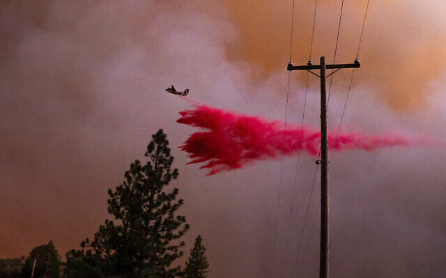 A plane drops retardant while battling the Oak Fire in Mariposa County, Calif., on Friday, July 22, 2022. (AP Photo/Noah Berger)