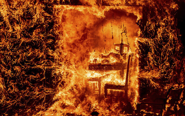 Flames engulf a chair inside a burning home as the Oak Fire burns in Mariposa County, California, July 23, 2022. (AP Photo/Noah Berger)