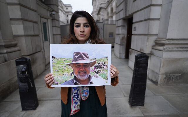 Roxanne Tahbaz holds a picture of her father Morad Tahbaz who is jailed in Iran, during a protest outside the Foreign, Commonwealth and Development Office in London, April 13, 2022. (Stefan Rousseau/PA via AP, File)
