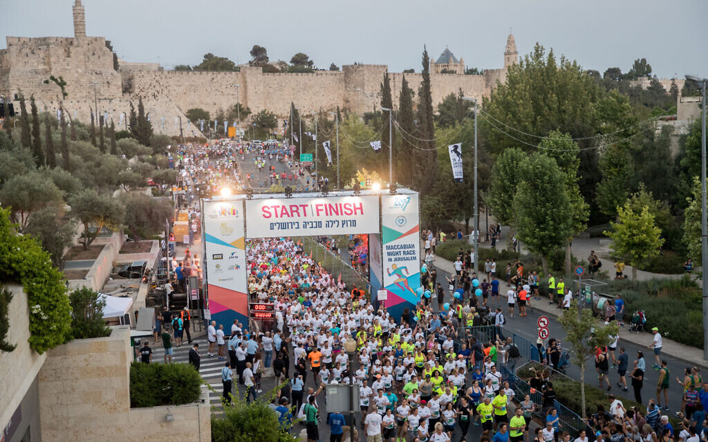 Illustrative: Runners take part in the Maccabiah Night Run next to the walls of Jerusalem’s Old City on July 10, 2017. (Yonatan Sindel/Flash90)