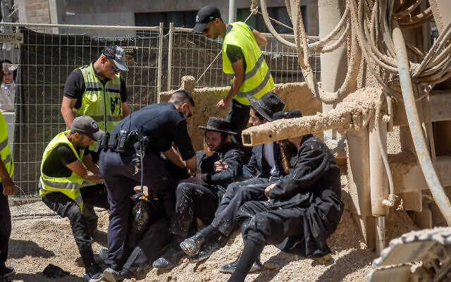 Illustrative: Ultra-Orthodox men clash with police and security guards during a protest against construction work for the Jerusalem Light Rail, on June 8, 2022. (Yonatan Sindel/ Flash90)