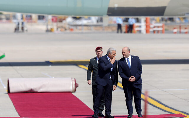 Prime Minister Yair Lapid and Alternate Prime Minister Naftali Bennett at the welcoming ceremony for US President Joe Biden at Ben Gurion Airport on July 13, 2022 (Noam Revkin Fenton/Flash90)