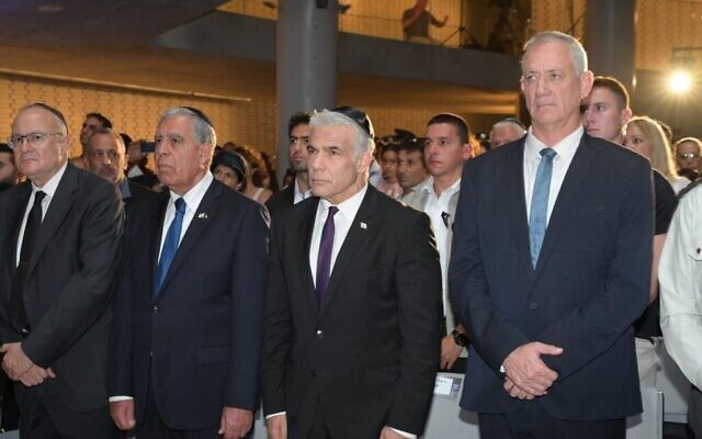 Prime Minister Yair Lapid and Defense Minister Benny Gantz at a state ceremony on Mount Herzl commemorating fallen soldiers in Operation Protective Edge, July 10, 2022. (Amos Ben Gershom/ GPO)