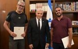 Prime Minister Yair Lapid, center, honors Meshi Ben Ami, left, and Haim Naim, at the Prime Minister's Office, Jerusalem, July 20, 2022. (Amos Ben Gershom/GPO)