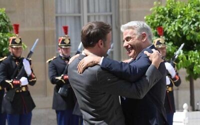 Prime Minister Yair Lapid (R) embraces French President Emmanuel Macron at a press conference at the Elysee Palace in Paris, France, July 5, 2022. (Amos Ben Gershom/GPO)