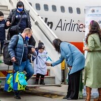 Minister Pnina Tamano-Shata, center, in blue coat, welcomes new immigrants from Ukraine at Ben-Gurion airport in Israel, in undated photos distributed by the Immigration and Absorption Ministry on July 6, 2022. (Courtesy Naga Malasa)