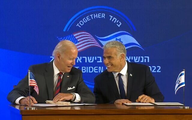 US President Joe Biden (left) and Prime Minister Yair Lapid sign the Jerusalem Declaration at the Waldorf Astoria Hotel in Jerusalem, July 14, 2022. (Screenshot)