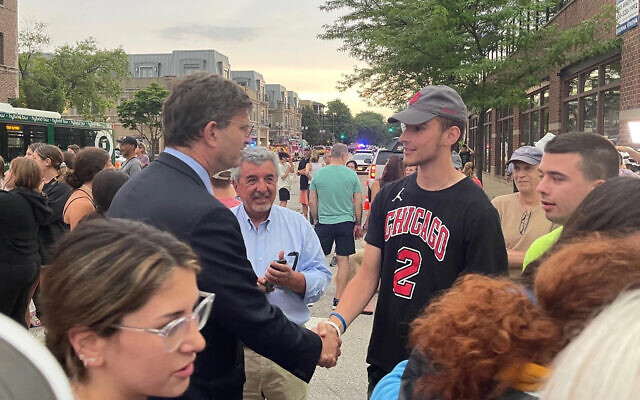 Rep. Brad Schneider, left, chats with a constituent two days after a mass shooting, in Highland Park, Ill., July 6, 2022. (Twitter via JTA)