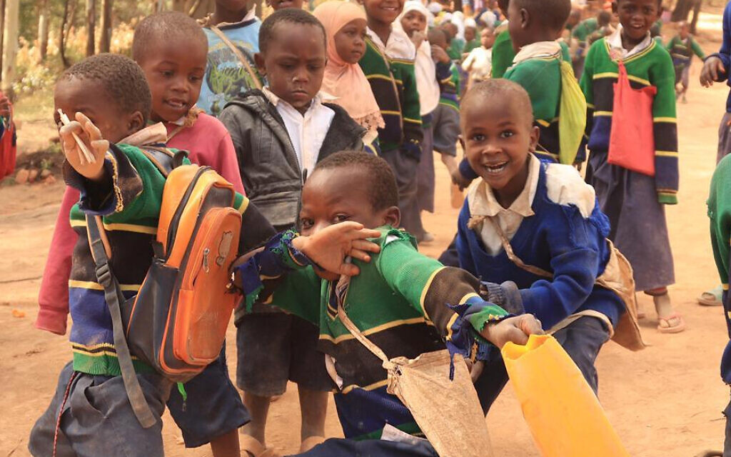 Children in Malindi, Tanzania wear school uniforms in the colors of the Tanzanian flag procured by Afrikan's second delegation (May 2022). Families who were unable to afford the uniforms were not sending their children to school. (Courtesy of Afrikan)