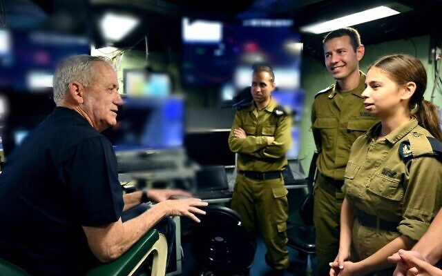 Defense Minister Benny Gantz speaks with IDF Sgt. Shachar Furman at the Haifa naval base, July 12, 2022. (Ariel Hermoni/Defense Ministry)