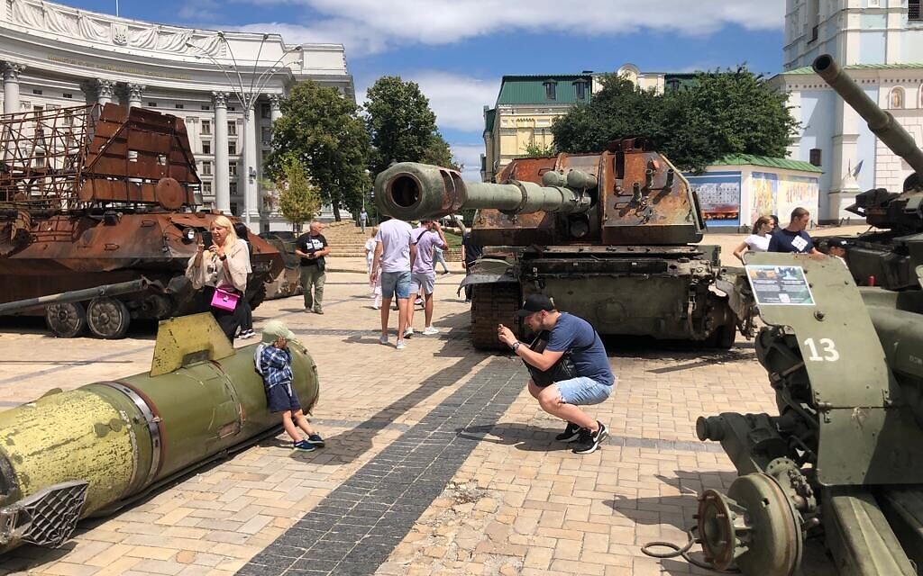 A father photographs his son against a Russian missile in Old Kyiv, July 21, 2022. (Lazar Berman/The Times of Israel)