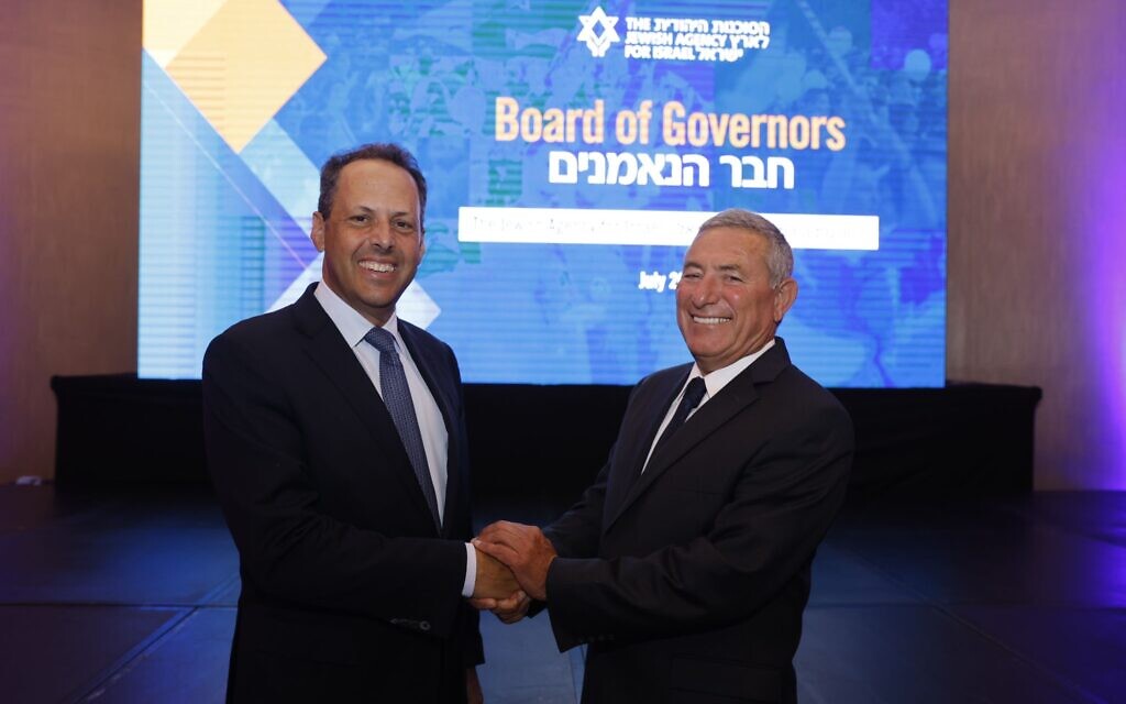 Incoming chairman of the Jewish Agency board of governors, Mark Wilf, left, shakes hands with incoming chairman of the Jewish Agency's executive, Doron Almog, after they both were elected on July 10, 2022. (Olivier Fitoussi/Jewish Agency)